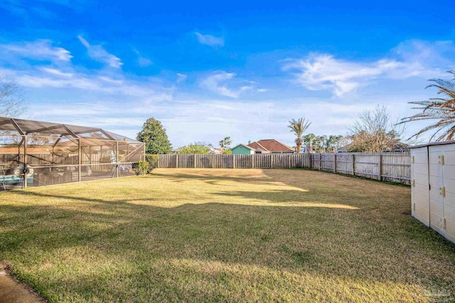 view of yard with a fenced backyard and a lanai