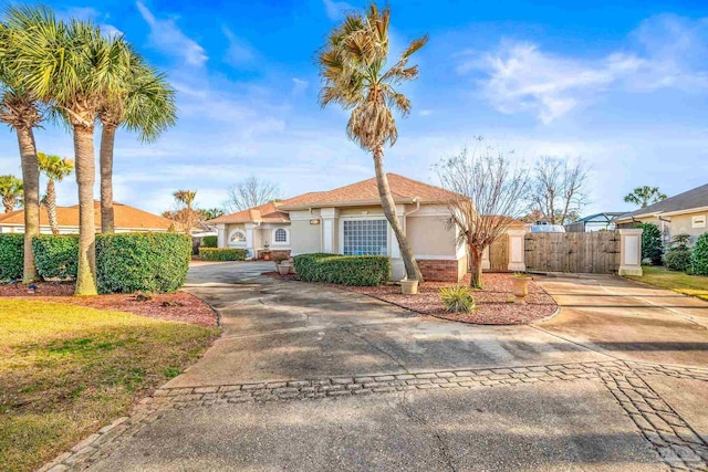 mediterranean / spanish-style home with driveway, a gate, fence, and stucco siding