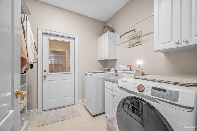 laundry room with light tile patterned floors, cabinet space, baseboards, and separate washer and dryer