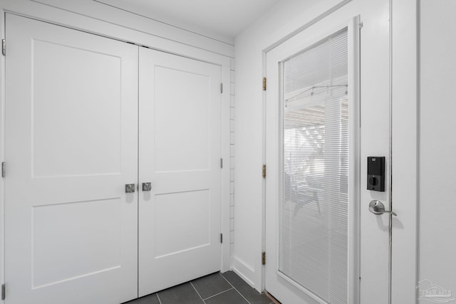 entryway with dark tile patterned floors