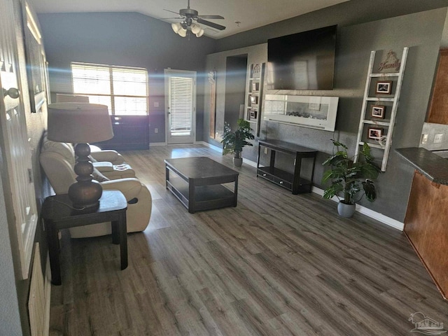 living room with vaulted ceiling, wood finished floors, a ceiling fan, and baseboards