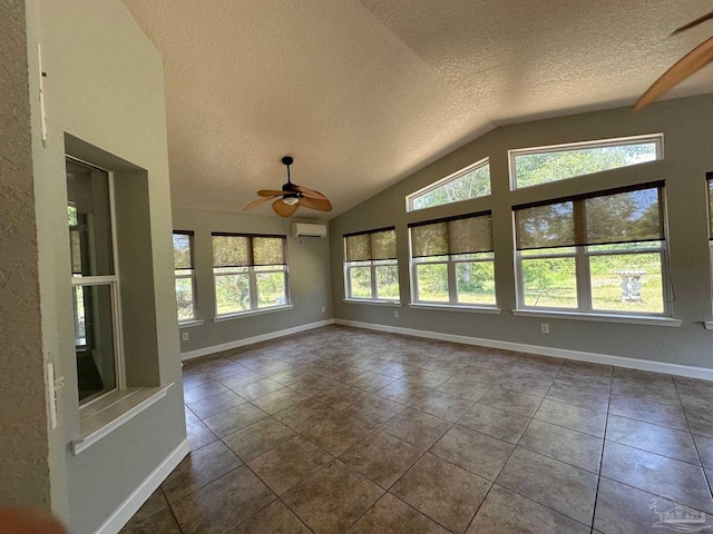 unfurnished sunroom featuring ceiling fan, lofted ceiling, and a wall unit AC