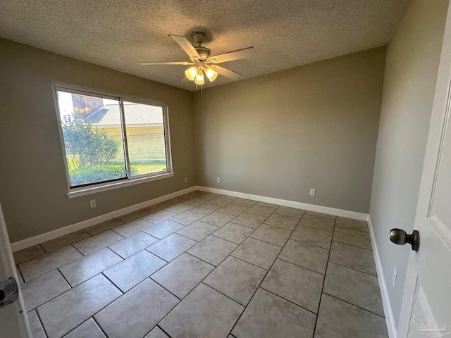 tiled spare room featuring ceiling fan and a textured ceiling