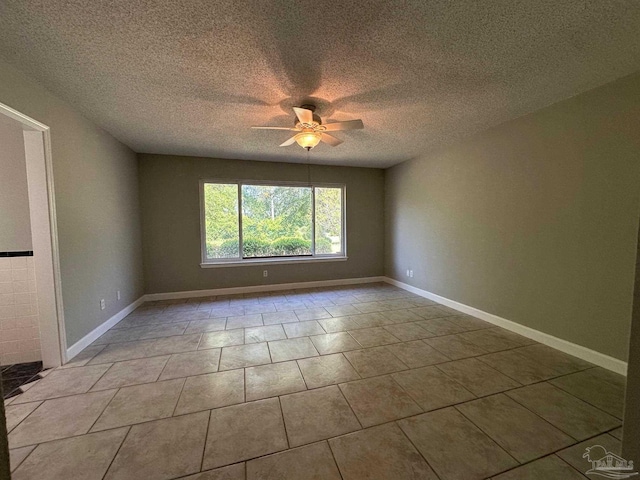 tiled spare room with a textured ceiling and ceiling fan