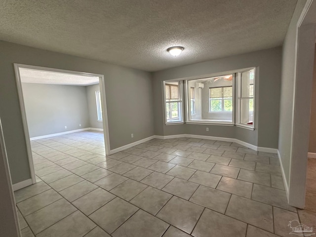 spare room featuring light tile patterned floors and a textured ceiling