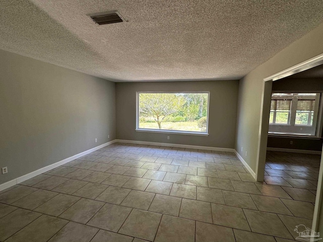 empty room featuring tile patterned floors and a textured ceiling