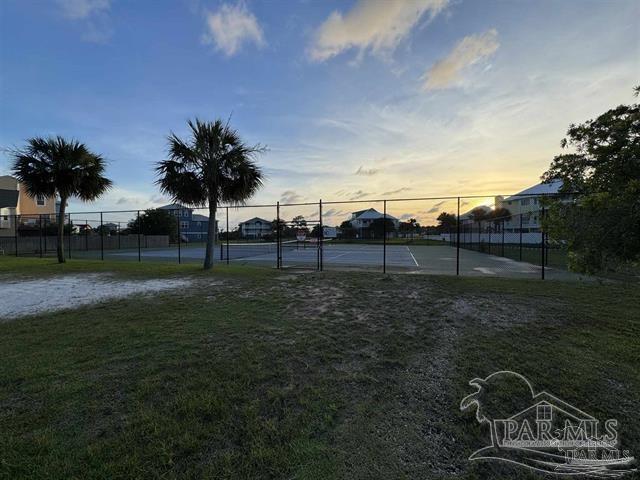 view of property's community featuring a yard and tennis court