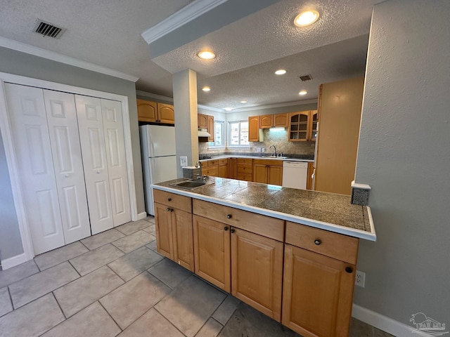 kitchen with a textured ceiling, light tile patterned floors, ornamental molding, white appliances, and decorative backsplash