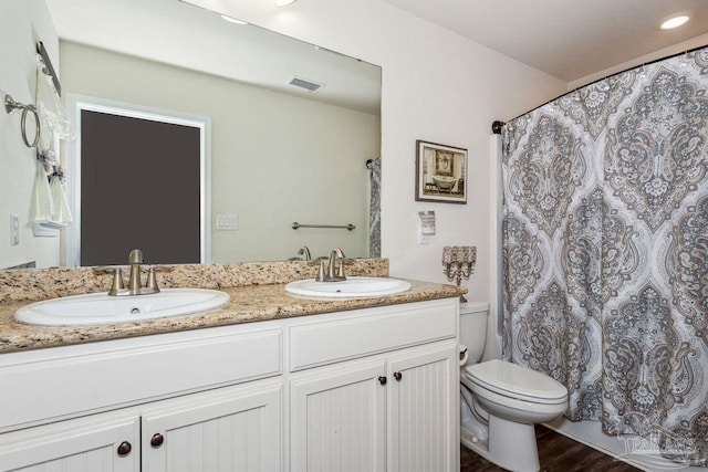 bathroom with hardwood / wood-style flooring, vanity, and toilet