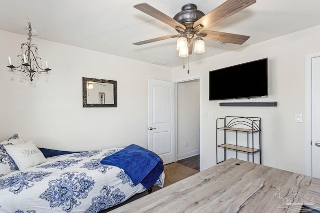 bedroom featuring ceiling fan with notable chandelier