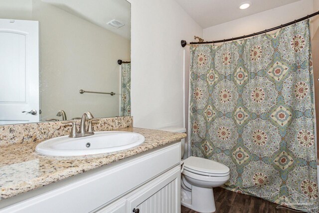 bathroom featuring a shower with curtain, hardwood / wood-style floors, vanity, and toilet