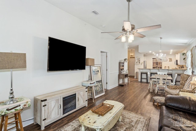 living room with ceiling fan with notable chandelier, dark hardwood / wood-style flooring, and lofted ceiling