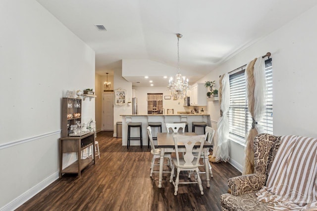 dining area with a notable chandelier, dark hardwood / wood-style flooring, and vaulted ceiling