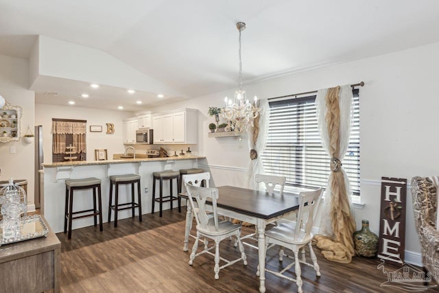 dining room with an inviting chandelier, vaulted ceiling, dark wood-type flooring, and sink