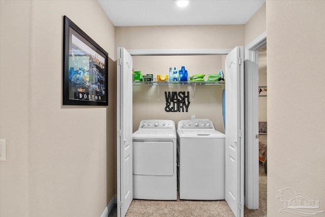 laundry area with washer and clothes dryer and light colored carpet