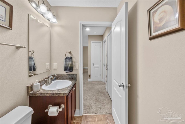 bathroom featuring tile patterned flooring, vanity, and toilet