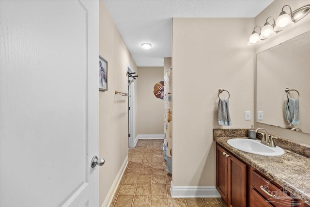 bathroom featuring a textured ceiling and vanity