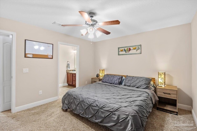 carpeted bedroom with ensuite bath and ceiling fan