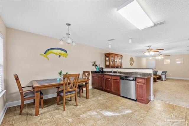 kitchen with a wealth of natural light, stainless steel dishwasher, and decorative light fixtures