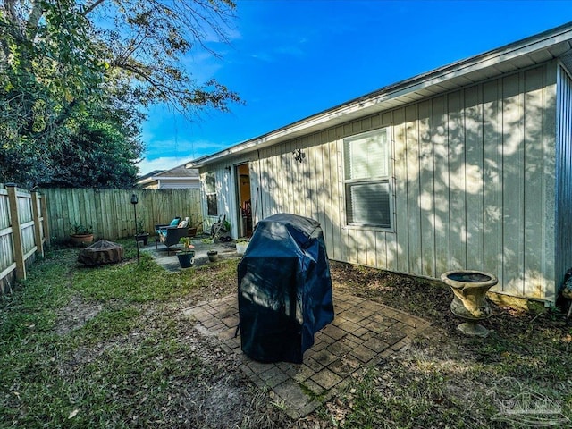 rear view of property featuring a patio and an outdoor fire pit