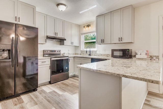 kitchen with fridge with ice dispenser, electric range, under cabinet range hood, a peninsula, and black microwave