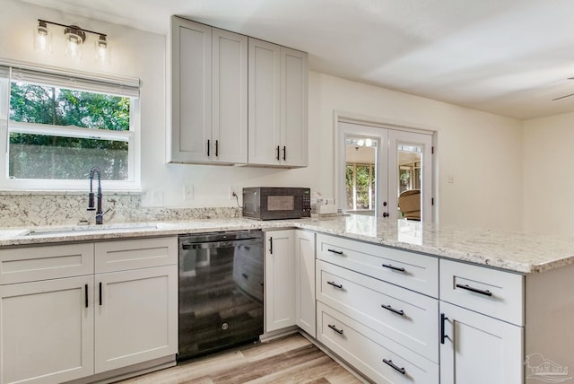 kitchen featuring a sink, plenty of natural light, black appliances, and a peninsula