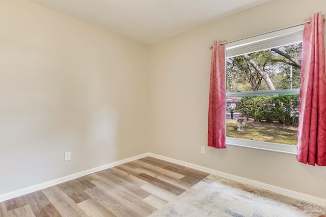 spare room featuring wood finished floors and baseboards