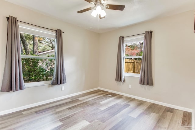 unfurnished room with wood finished floors, baseboards, and ceiling fan