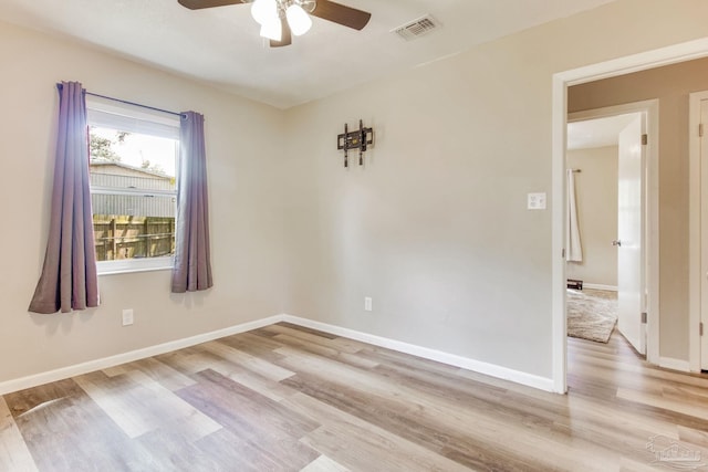 spare room with visible vents, baseboards, light wood-style floors, and a ceiling fan