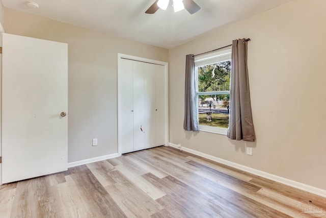 unfurnished bedroom with a ceiling fan, wood finished floors, baseboards, and a closet