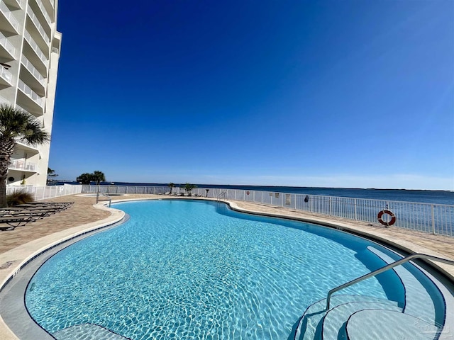 view of pool featuring a water view and a patio