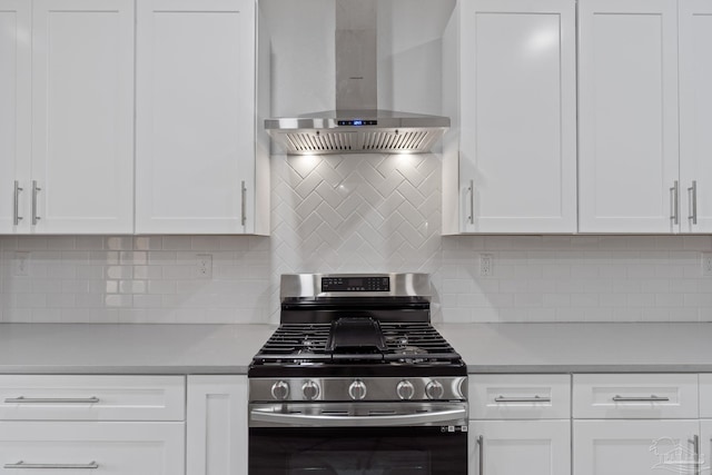 kitchen featuring white cabinetry, wall chimney range hood, and stainless steel gas range