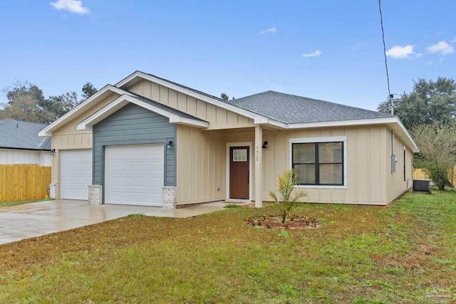 view of front of property with a front yard, a garage, and central AC unit