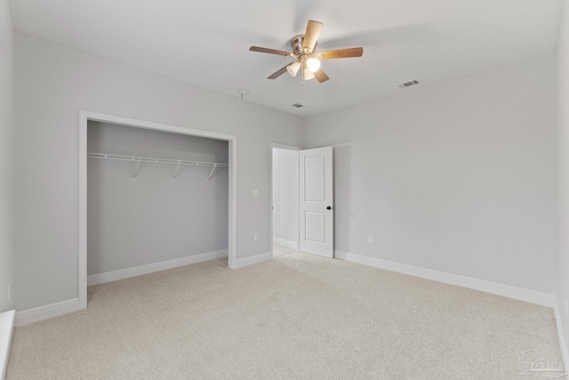 unfurnished bedroom featuring ceiling fan, light carpet, and a closet