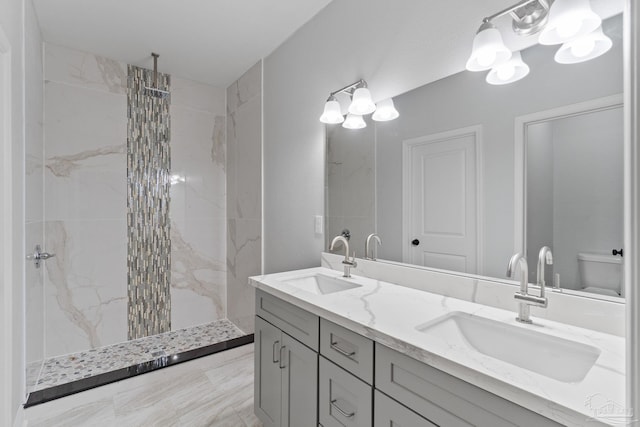 bathroom with vanity, toilet, and a tile shower