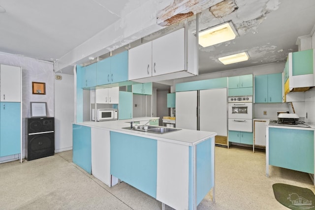 kitchen featuring white appliances, a center island, sink, and white cabinets