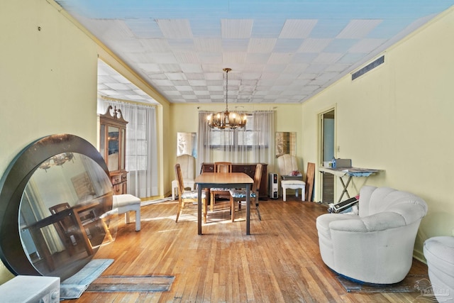 dining area featuring hardwood / wood-style floors and a notable chandelier