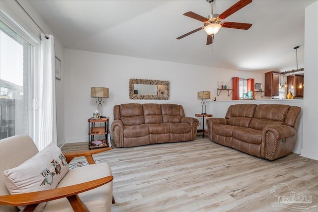 living room with plenty of natural light, ceiling fan, and light wood-type flooring