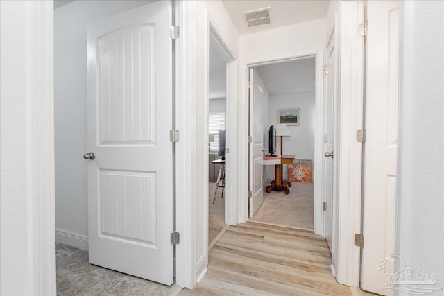 hallway featuring light carpet