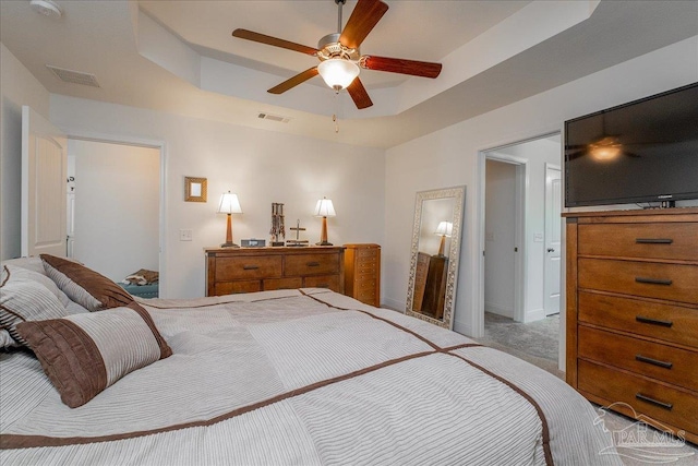 bedroom with a tray ceiling and ceiling fan