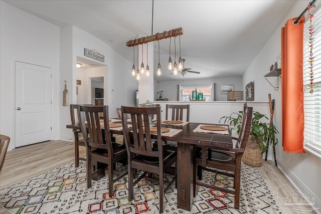 dining area featuring lofted ceiling and light wood-type flooring