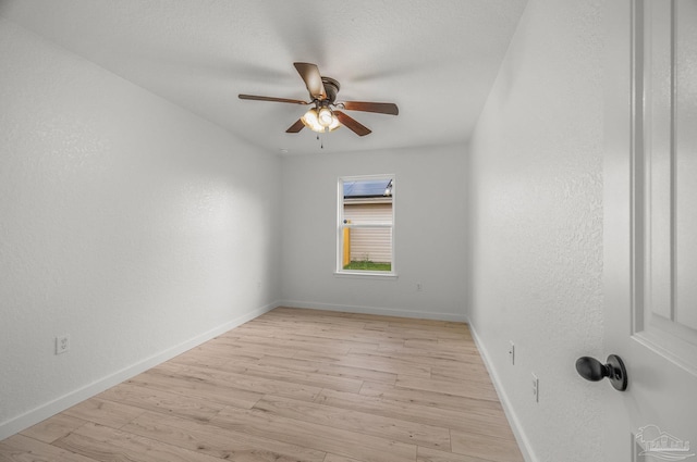 spare room with baseboards, ceiling fan, and light wood-style flooring