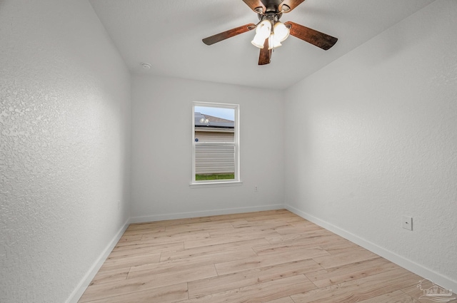 empty room with ceiling fan, a textured wall, baseboards, and light wood finished floors