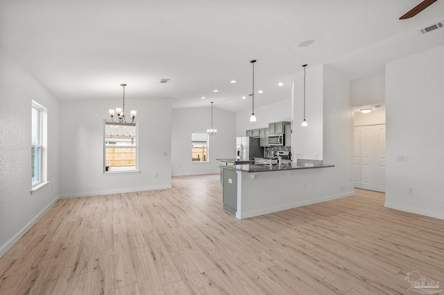 kitchen featuring visible vents, appliances with stainless steel finishes, light wood-type flooring, a sink, and a peninsula