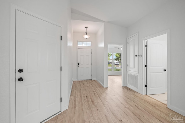 foyer featuring baseboards, visible vents, and light wood finished floors