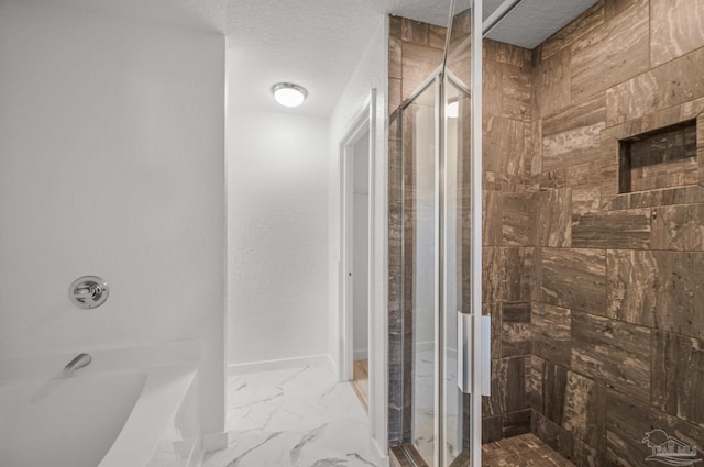 bathroom featuring a washtub, a textured ceiling, marble finish floor, and a stall shower