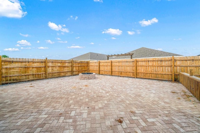 view of patio featuring a fenced backyard and a fire pit