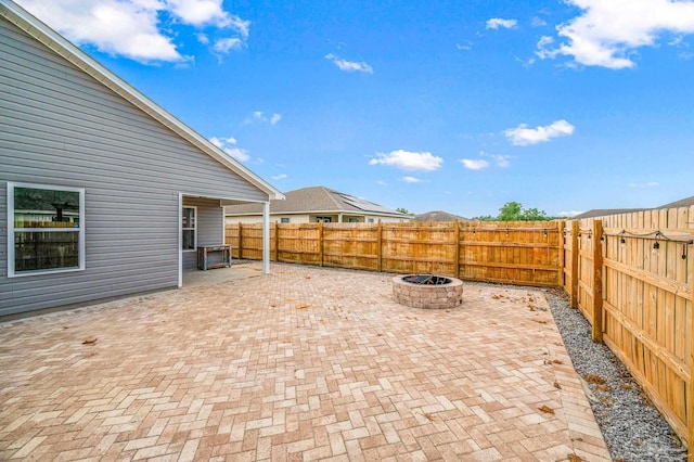 view of patio with a fenced backyard and a fire pit