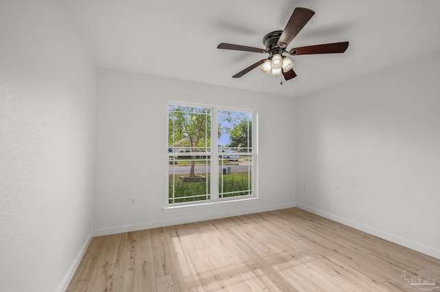 empty room with light wood-style floors, baseboards, and a ceiling fan