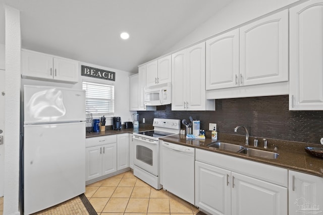 kitchen featuring white cabinetry, lofted ceiling, sink, light tile patterned floors, and white appliances